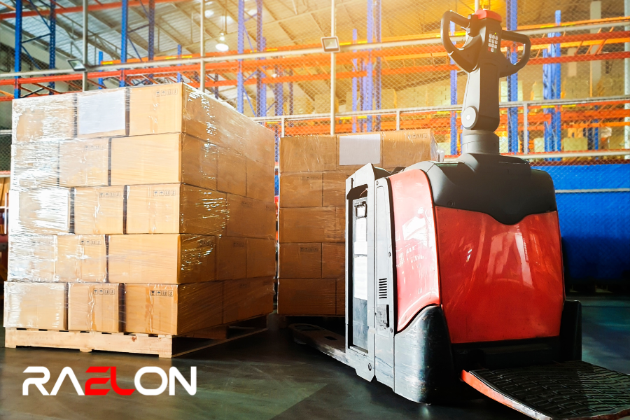 Electric pallet jack loading pallets in warehouse with orange racking and tight aisle space