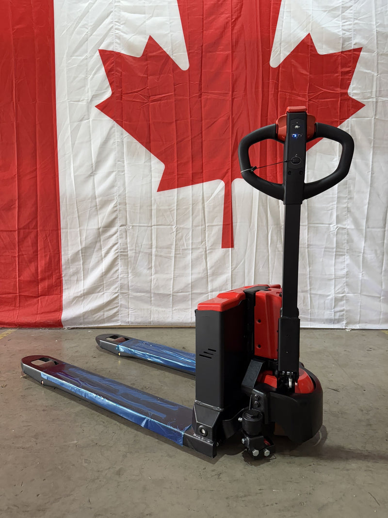 Front three-quarter view of the Raelon CBD15W-II electric pallet jack in the Richmond warehouse, showing the hydraulic unit, battery box and 48 in forks